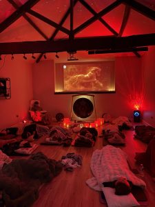 A sound bath in a studio with a colourful backgound